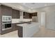 An open kitchen featuring dark wood cabinets, stainless steel appliances, and a center island at 11297 Essence Point Ave # 102, Las Vegas, NV 89135