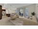 Bright, staged living room with neutral furniture, an open layout, and sliding glass doors to the patio at 11297 Essence Point Ave # 102, Las Vegas, NV 89135