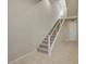 Modern staircase with carpeted steps, a white railing, and tile flooring in the entryway at 11297 Essence Point Ave # 102, Las Vegas, NV 89135