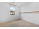 Bright bedroom with neutral walls, carpet, a single shelf, and a window overlooking a neighborhood at 11756 Emerald Lake Ave, Las Vegas, NV 89138
