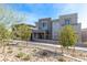Modern home exterior with desert landscaping and a mix of stone and gray facade at 11756 Emerald Lake Ave, Las Vegas, NV 89138