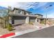 Home exterior with two-car garages, brick driveway and manicured landscaping along the sidewalk at 11756 Emerald Lake Ave, Las Vegas, NV 89138