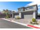 Two-car garages of a modern home with brick driveway and meticulously maintained landscaping at 11756 Emerald Lake Ave, Las Vegas, NV 89138