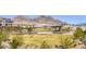 Aerial view of a grassy park with a modern shade structure and mountain views in the background at 11756 Emerald Lake Ave, Las Vegas, NV 89138