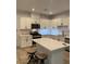 Well-lit kitchen featuring white cabinetry, stainless steel appliances, and a center island with seating at 1197 Mission View Ct, Henderson, NV 89002