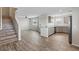 Open-concept living room with wood floors, stairs, and an open view into the kitchen at 12108 Harvest Sky Way # 1, Las Vegas, NV 89183