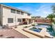 A luxurious backyard pool and spa featuring an outdoor kitchen and patio area, perfect for entertaining and relaxation at 1283 Peppercorn Ave, Henderson, NV 89012
