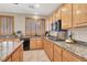 Modern kitchen with granite countertops, wood cabinetry, and stainless steel appliances, perfect for culinary enthusiasts at 1283 Peppercorn Ave, Henderson, NV 89012