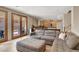 Spacious living room with ample seating, tile flooring, and glass doors leading to an outdoor space and open access to the kitchen at 1283 Peppercorn Ave, Henderson, NV 89012