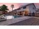 Expansive backyard oasis featuring a pool with water features, a covered patio, and ample space for outdoor dining at 1283 Peppercorn Ave, Henderson, NV 89012