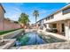 Stunning backyard pool with sun-drenched patio and elegant water features surrounded by palms at 1283 Peppercorn Ave, Henderson, NV 89012