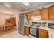 View of kitchen with oak cabinets, stainless steel appliances, and dining area with chandelier at 1375 E Hacienda Ave # 114, Las Vegas, NV 89119