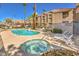 Community pool and jacuzzi surrounded by well-maintained landscaping and multi-story buildings at 1375 E Hacienda Ave # 114, Las Vegas, NV 89119