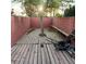 Fenced backyard with mature tree, brick wall, and wooden patio at 1732 Yellow Rose St, Las Vegas, NV 89108