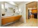 Modern bathroom vanity with a large mirror and granite countertop, leading to a kitchen area at 211 E Flamingo Rd # 714, Las Vegas, NV 89169