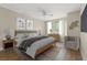 Bright bedroom with ceiling fan, wood floors, neutral walls, modern art, and a sitting chair by the window at 2292 Cassatt Dr, Henderson, NV 89074