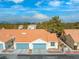 Charming townhome showcases blue garage doors, a red tile roof, and desert landscaping at 2292 Cassatt Dr, Henderson, NV 89074
