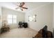 Bright bedroom featuring a ceiling fan, shuttered windows, neutral carpet, and decorative mirror at 2388 Aztec Ruin Way, Henderson, NV 89044