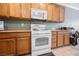 Kitchen with wooden cabinets and white appliances at 2388 Aztec Ruin Way, Henderson, NV 89044