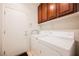 Laundry area with a washer, dryer, upper cabinets and access to the garage at 2388 Aztec Ruin Way, Henderson, NV 89044