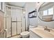 Bathroom featuring glass enclosed shower, vanity with round mirror, and a small window at 2540 Eagle St, Las Vegas, NV 89142