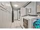 Bright laundry room features washer, dryer and ample storage with white cabinets at 2540 Eagle St, Las Vegas, NV 89142