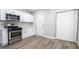 Well-lit kitchen featuring stainless steel appliances, white cabinets, and gray wood-look flooring at 2990 La Canada St, Las Vegas, NV 89169