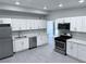 Modern kitchen featuring stainless steel appliances, white cabinets, and stylish gray flooring at 2990 La Canada St, Las Vegas, NV 89169
