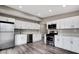 Modern kitchen with stainless steel appliances, white cabinets, and stylish gray wood-look flooring at 2990 La Canada St, Las Vegas, NV 89169