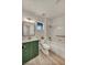 Bright bathroom with a green vanity, gold hardware, and a tub with a shower at 3009 Anna Bay Dr, Las Vegas, NV 89134
