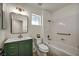 Charming bathroom with a green vanity, gold hardware, and a tub with a shower at 3009 Anna Bay Dr, Las Vegas, NV 89134