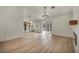 Open-concept living room with wood floors, fireplace, stylish chandelier, and seamless flow to kitchen and patio at 3009 Anna Bay Dr, Las Vegas, NV 89134