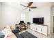 Bedroom with neutral decor, a ceiling fan, a workstation, and a large television at 3096 Beaux Art Ave, Henderson, NV 89044