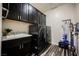 The laundry room features a dark washer and dryer, dark cabinets, granite countertops, and tile floor at 3096 Beaux Art Ave, Henderson, NV 89044