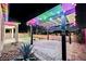 Backyard with a covered patio, pavers, turf, and ambient lighting creates a warm and inviting atmosphere for enjoyment at 3096 Beaux Art Ave, Henderson, NV 89044