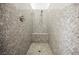 A luxurious shower features a built-in seat, elegant fixtures, and attractive stone-patterned tile at 3096 Beaux Art Ave, Henderson, NV 89044
