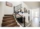 Elegant staircase with a wine bar featuring a wine cooler, black cabinets, and wrought iron banister at 3096 Beaux Art Ave, Henderson, NV 89044