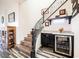 Elegant staircase with a wine bar featuring a wine cooler and granite countertop for a touch of luxury at 3096 Beaux Art Ave, Henderson, NV 89044