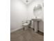 Bathroom featuring a pedestal sink, round mirror, and tiled floor at 3610 Tripoli Cove Ave, Las Vegas, NV 89106
