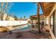 Backyard pool with decorative rock surround, covered patio, and white privacy fence at 364 Rushing Creek Ct, Henderson, NV 89014