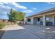 An outdoor patio with table, chairs and desert landscaping with a view of mature trees in this backyard at 3841 Budenny Dr, Las Vegas, NV 89122