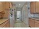 A kitchen with light wood cabinets, white appliances, and a tile floor leads to an adjacent space at 3841 Budenny Dr, Las Vegas, NV 89122