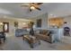 Spacious living room featuring comfortable sofas, a ceiling fan, and access to dining/kitchen at 3841 Budenny Dr, Las Vegas, NV 89122