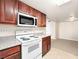 Kitchen with wood cabinets and white appliances is open to a carpeted room at 5339 Indian River Dr # 281, Las Vegas, NV 89103