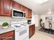 Cozy kitchen with wood cabinets, white appliances, open to dining area with table and chairs at 5339 Indian River Dr # 281, Las Vegas, NV 89103
