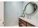 Chic powder room with a wood vanity, marble countertop, round mirror, and stylish fixtures at 537 Tuscany View St, Las Vegas, NV 89145