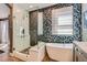 Modern bathroom features a glass shower and freestanding tub against an accent wall with patterned tile at 537 Tuscany View St, Las Vegas, NV 89145