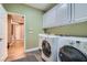 Bright laundry room with front load washer and dryer and white cabinets at 537 Tuscany View St, Las Vegas, NV 89145