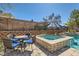 Relaxing poolside seating area with a charming table and chairs next to the spa and glistening pool at 537 Tuscany View St, Las Vegas, NV 89145