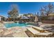 Backyard pool with travertine tile deck, lounge chairs, mature trees and a privacy fence at 537 Tuscany View St, Las Vegas, NV 89145